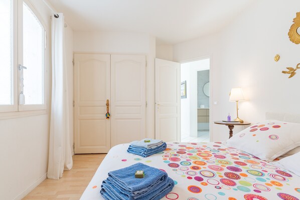 A hotel room with a bed, a nightstand, a lamp, and a door. - Villa "Chez Dominique" with Private Pool, Private Terrace, and Wi-Fi (Manosque)