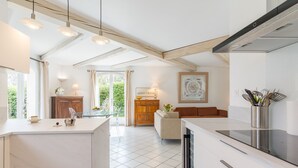 Una cocina moderna con una isla central, armarios de madera y un área de comedor con sofá.