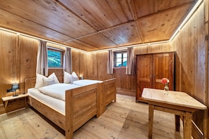 Une pièce en bois avec un lit, une table et une armoire.