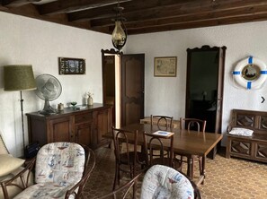 A dining area with a wooden table, chairs, a fan, and a lamp. - Holiday Home 'Piraillan Foret' with Private Garden (Lège-Cap-Ferret)