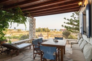 Un espacio de estar al aire libre cubierto con paredes de piedra, una mesa y sillas.