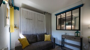 Un salon moderne avec un canapé, une console et une grande fenêtre.