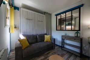 Un salon moderne avec un canapé, une console et une grande fenêtre.