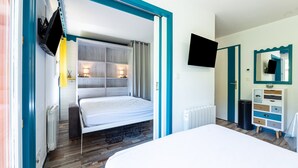 Une chambre à coucher avec un lit, une télévision, une commode et un miroir.