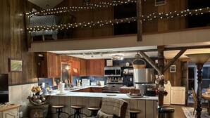 A cozy kitchen with wooden cabinets, a central island, and bar stools.