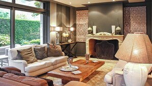 A modern living room with a fireplace, a sofa, a coffee table, and a lamp.
