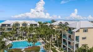 Ein Resort mit mehreren Gebäuden, einem Schwimmbecken und Palmen.