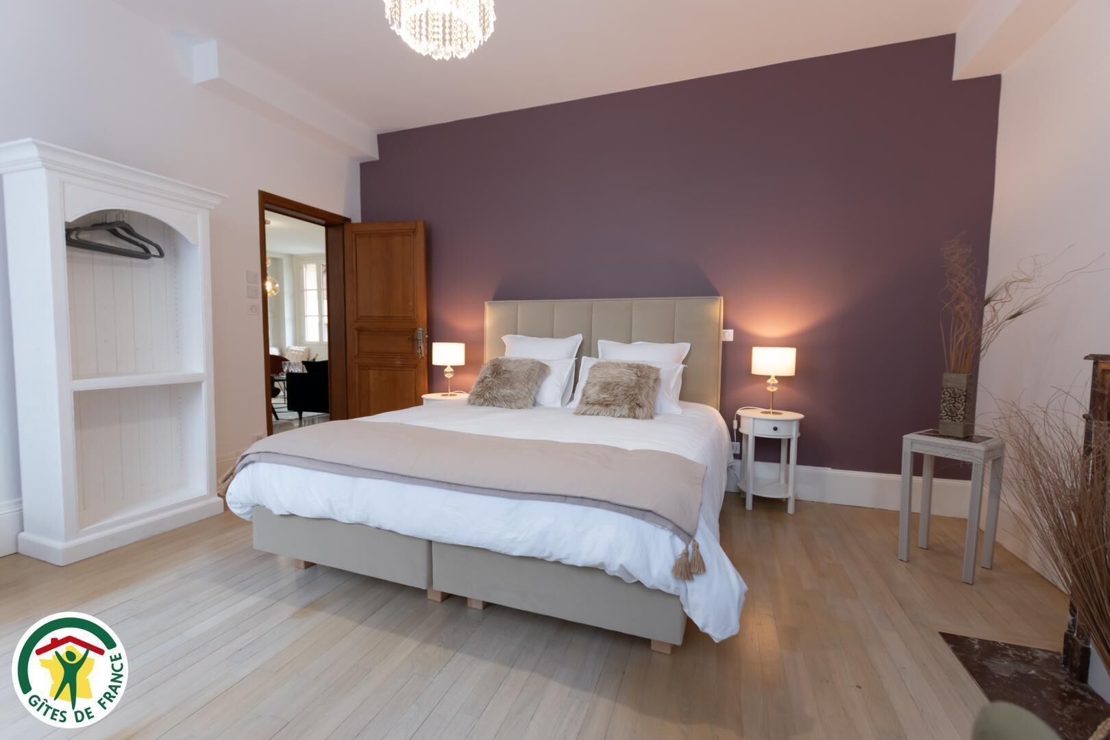 A bedroom with a bed, bedside tables, a wardrobe, and a mirror.