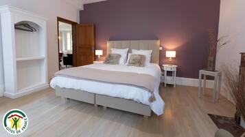 A bedroom with a bed, bedside tables, a wardrobe, and a mirror.