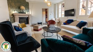 Een woonkamer met een open haard, een televisie en een bank.