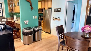 A modern kitchen with wooden cabinets, stainless steel appliances, and a dining area with a wooden table and chairs. - Cozy/Relaxing Retreat in the 💖 of Mammoth, near 🏔⛷❄️🏌️🏊‍♀️🌊 (Mammoth Lakes)
