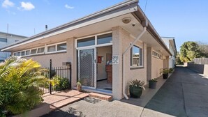 A single-story house with a front porch, a garage, and a small office area. - Browns Broadbeach (Mermaid Beach)