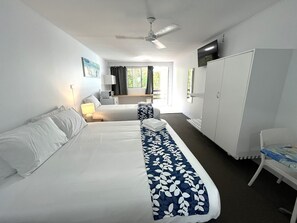 A hotel room with two beds, a wardrobe, a desk, a chair, a TV, and a ceiling fan. - Browns Broadbeach (Mermaid Beach)