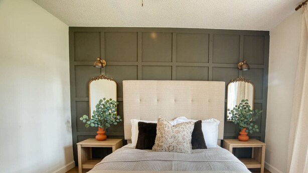 A bedroom with a large bed, two nightstands, two wall-mounted mirrors, and a potted plant on each nightstand. - Southern Travel - Charming 3 BR (Moultrie)