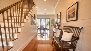 A wooden staircase leading to a dining area with a bench and a table. - Southern Farmhouse Retreat: 4 Bedroom, 4 Bath w/Master SPA like - Pet Friendly (Moultrie)