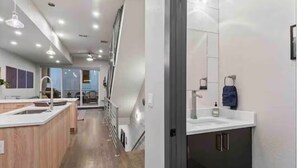 Een moderne keuken met een centraal eiland, een eethoek met uitzicht en een aparte badkamer met spiegel en handdoekrek.