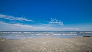 Een strand met een heldere lucht en rustige zee.