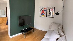 Una habitación moderna con televisión de pantalla plana, un banco y una cama.