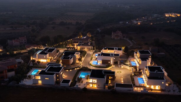 A modern residential area with multiple houses, a central swimming pool, and a view of the distant landscape. - Old Olive V by Interhome (Pula/Vodnjan)