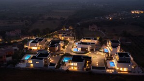 A modern residential area with multiple houses, a central swimming pool, and a view of the distant landscape. - Old Olive IV by Interhome (Pula/Vodnjan)