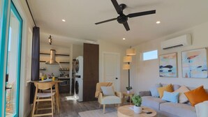 Una sala moderna con sofá, una mesa de centro y una zona de comedor con sillas y mesa.