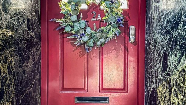 A red door with a wreath, a mailbox, and a keypad lock. - Studio - Sleeps 3 - Near Ealing Broadway Station (London)