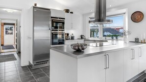 A modern kitchen with a stainless steel refrigerator, double ovens, and a large island with a sink. - "Elsi" - 1.3km from the sea by Interhome (Blåvand)