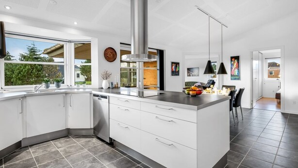 A modern kitchen with a large island, white cabinetry, and a stainless steel range hood. - "Elsi" - 1.3km from the sea by Interhome (Blåvand)