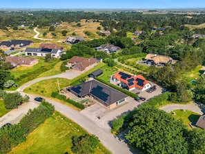 An aerial view of a residential area with houses, roads, and greenery.