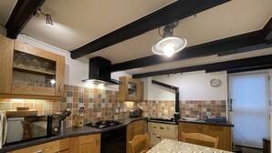 A kitchen with wooden cabinets, a stove, and a dining table with chairs.
