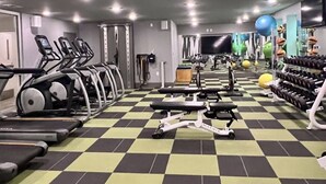 Une salle de sport équipée de tapis de course, de vélos d’appartement et d’appareils de musculation.