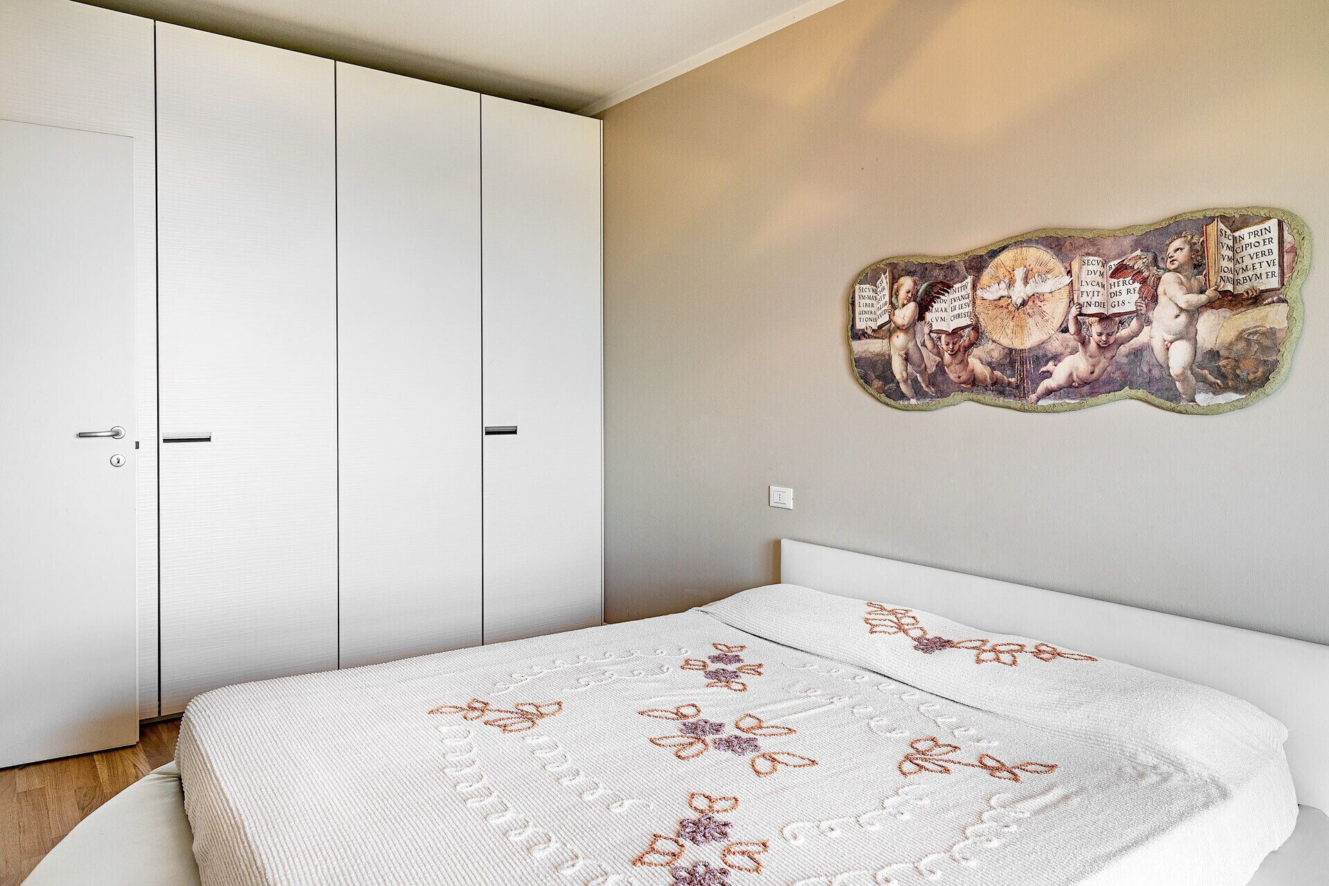 Une chambre à coucher avec un lit, une armoire et un élément de décoration murale.