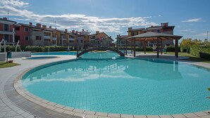 Une piscine avec un pont, entourée d’immeubles résidentiels à plusieurs étages.