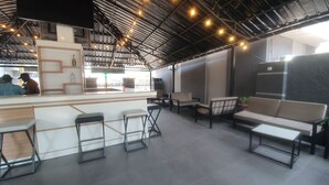 Zona de bar moderna amb un taulell, tamborets i seients.