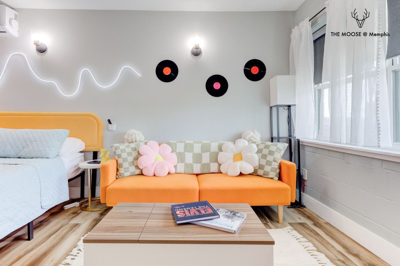 A modern living room with a sofa, a coffee table, and a wall with decorative elements.