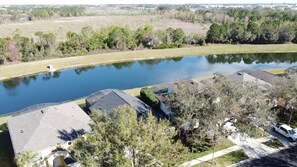A residential area with houses, a pond, and a road.
