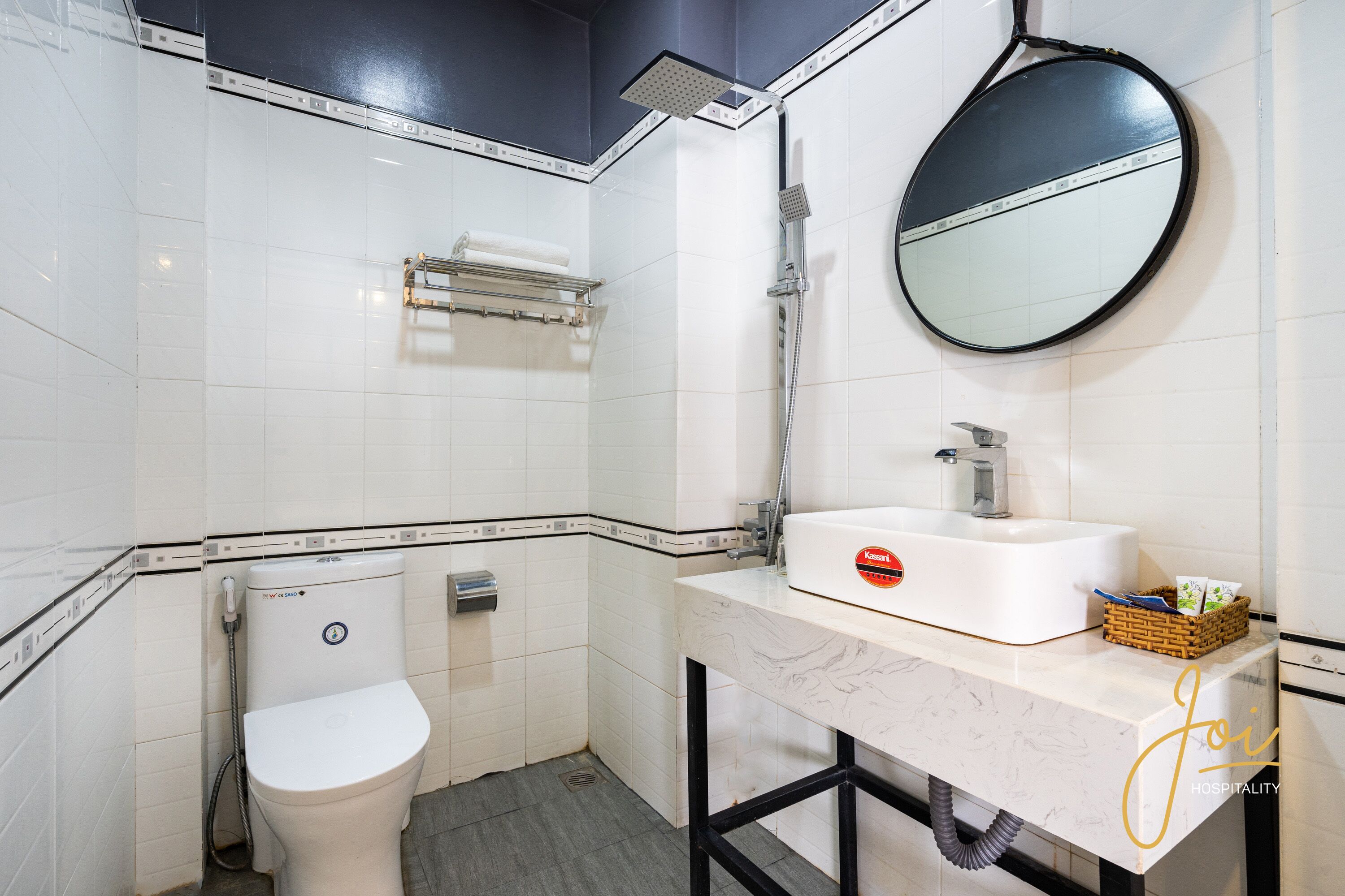 Un baño moderno con inodoro, lavamanos, espejo y ducha.