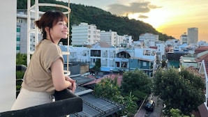 A balcony with a view of a residential area and a sunset. - Joi Hospitality - Hoang Anh (Ho Chi Minh City)