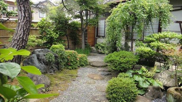 A traditional Japanese garden with a gravel path, rocks, and various plants. - Rakucho Ryokan (Kyoto)