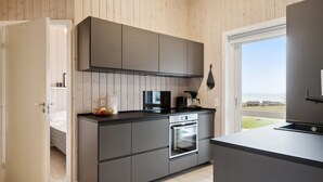 A modern kitchen with grey cabinets, a built-in oven, and a coffee machine. - "Halvor" - 275m from the sea by Interhome (Faaborg)