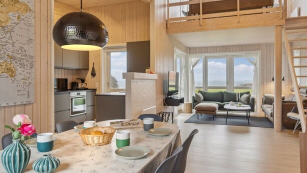 A spacious room with a high ceiling, a dining area with a table set for two, a kitchen area, and a seating area with a view of the outdoors. - "Halvor" - 275m from the sea by Interhome (Faaborg)