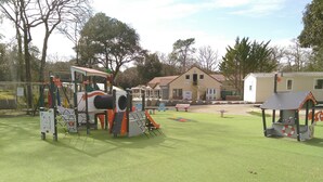 A playground with climbing structures and a small shelter.