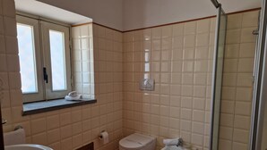 Un baño con inodoro, bidé y lavamanos.