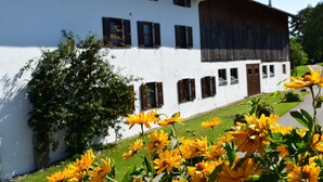 Ein weißes Gebäude mit vielen Fenstern und einem braunen Dach.