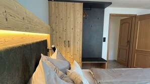 Ein Schlafzimmer mit einem Bett, Kissen, einem Holzschrank und einer Tür.