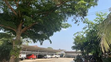 Uma área de estacionamento com vários carros e uma estrutura coberta ao fundo.