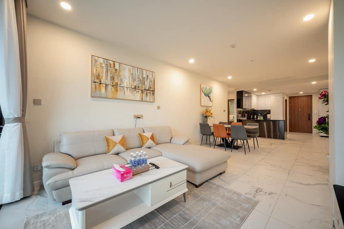 A modern living room with a sofa, coffee table, and dining area.