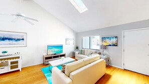 A modern living room with a flat-screen TV, a sofa, a coffee table, and artwork on the walls. - Beach Rd, 300ft to Beach Access & 500ft to Siesta Key Village, 2bdr (Siesta Key)
