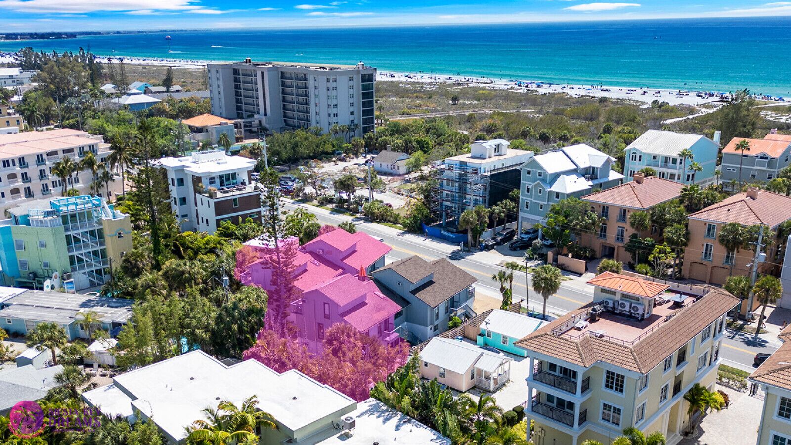 Zona residencial costera con edificios, una playa y una vista despejada del océano.