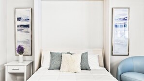 Ein modernes Schlafzimmer mit einem Bett, Nachttischen und Kunstwerken an den Wänden.